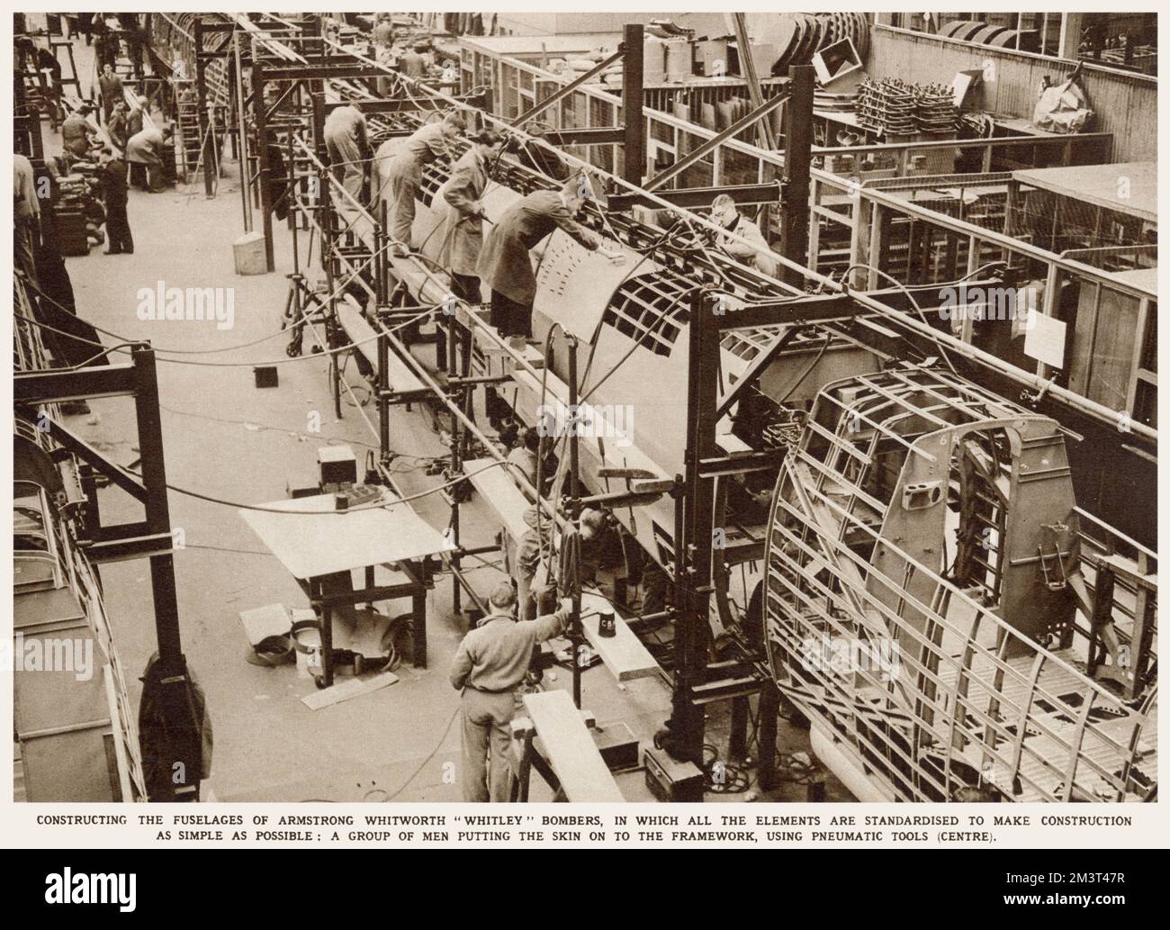 Un gruppo di uomini che lavorano alla fusoliera del bombardiere Whitley ad Armstrong Whitworth lavora a Coventry. Applicazione della pelle sul telaio mediante utensili pneumatici. Data: Marzo 1939 Foto Stock