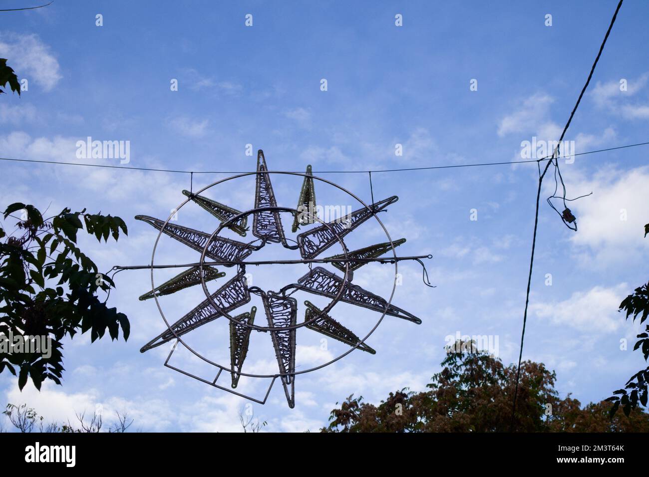 Immagine di un apparecchio di illuminazione a forma di stella spento per essere acceso durante le notti di Natale in una città Foto Stock Immagine di un apparecchio di illuminazione a forma di stella spento per essere acceso durante le notti di Natale in una città Foto Stock