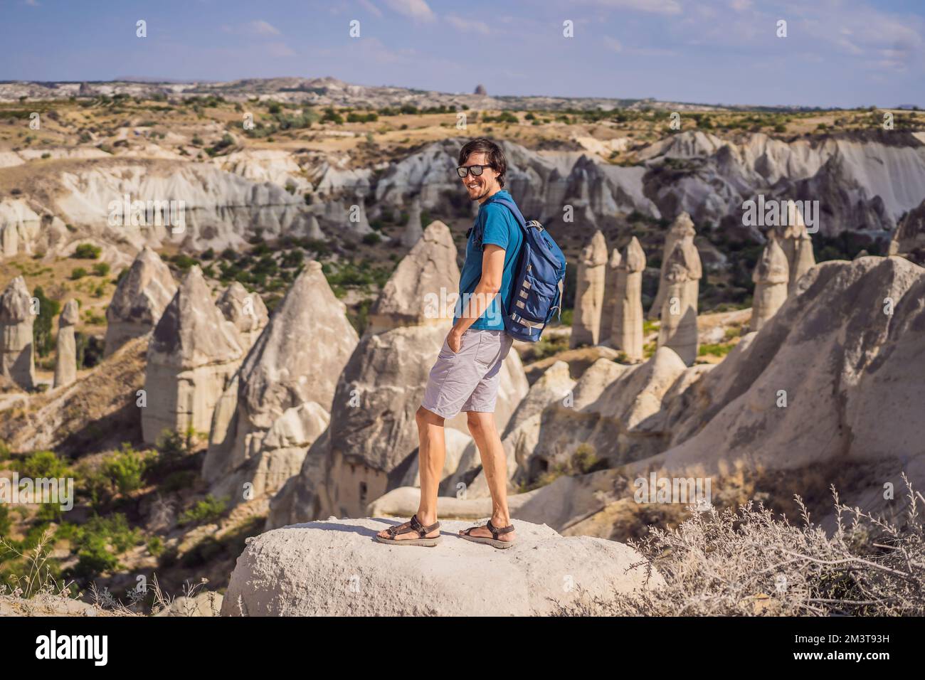 Giovane esploratore valle con formazioni rocciose e grotte delle fate vicino a Goreme in Cappadocia Turchia Foto Stock
