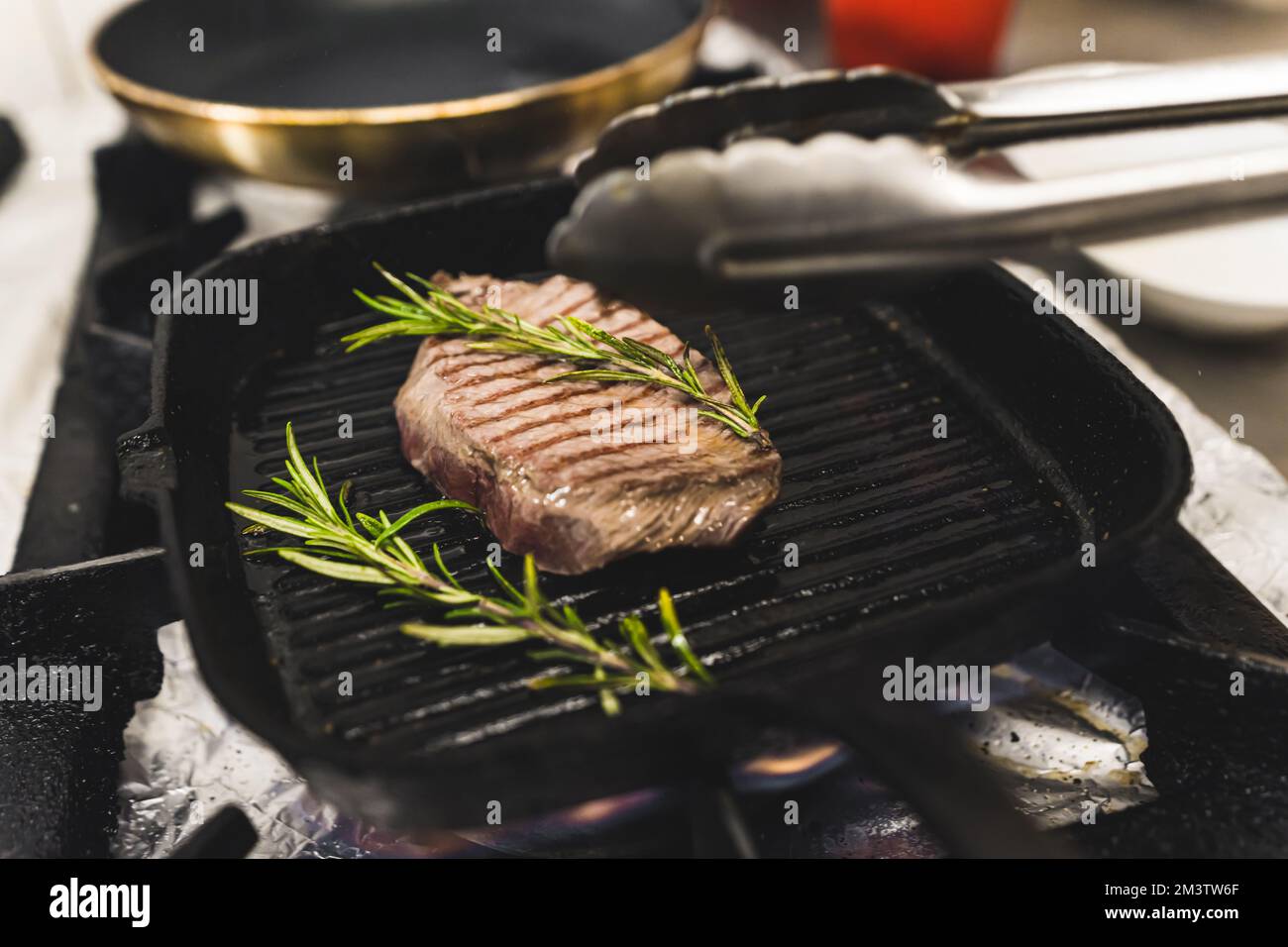 Bistecca alla griglia con rosmarino. Ricetta per una gustosa bistecca di lombo a casa utilizzando pochi ingredienti come le erbe. Foto di alta qualità Foto Stock