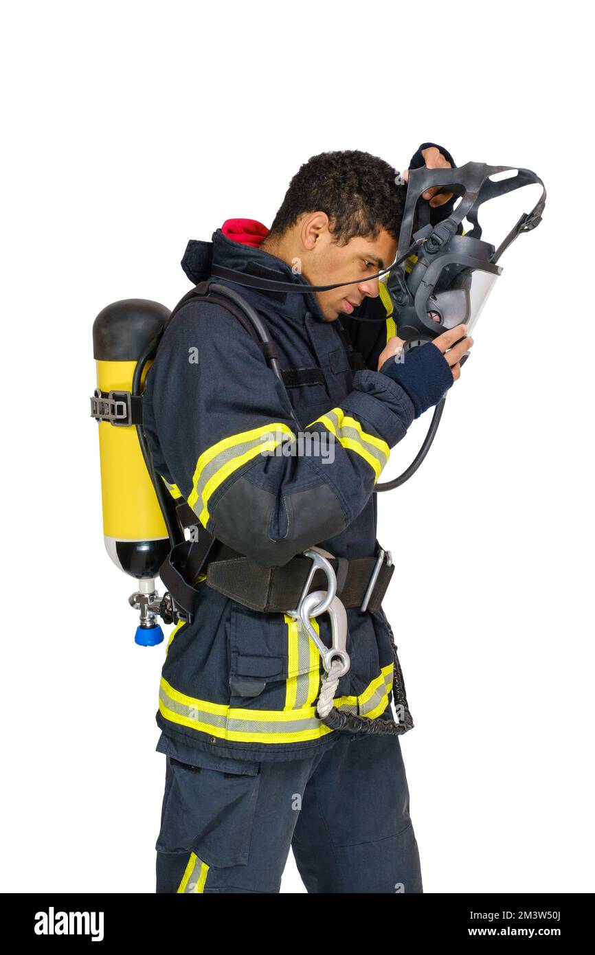 Pompiere in uniforme e con respiratore d'aria toglie la maschera protettiva Foto Stock