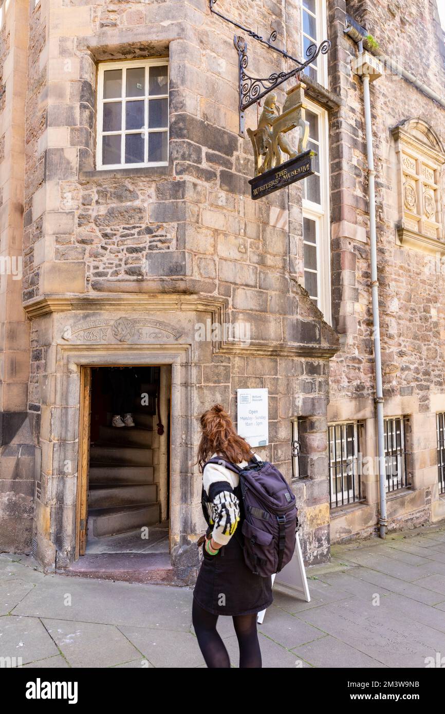 Giovane donna con zaino si trovava fuori dal Museo degli scrittori sul Royal Mile a Edimburgo, Scozia, Regno Unito estate 2022 Foto Stock