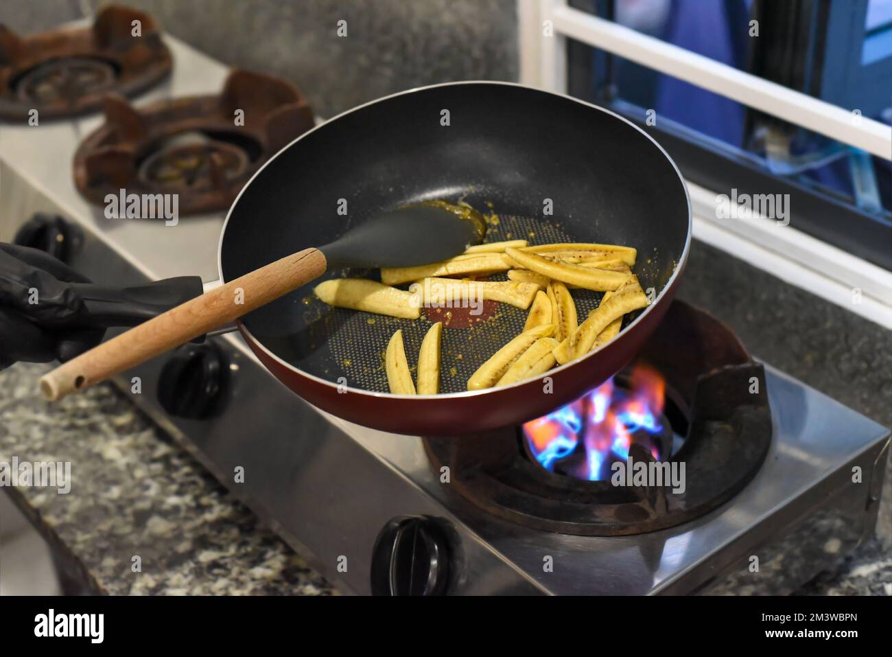 Banane friggere con whisky e sciroppo in una padella per santa fe messicana (banana caramellata) Foto Stock