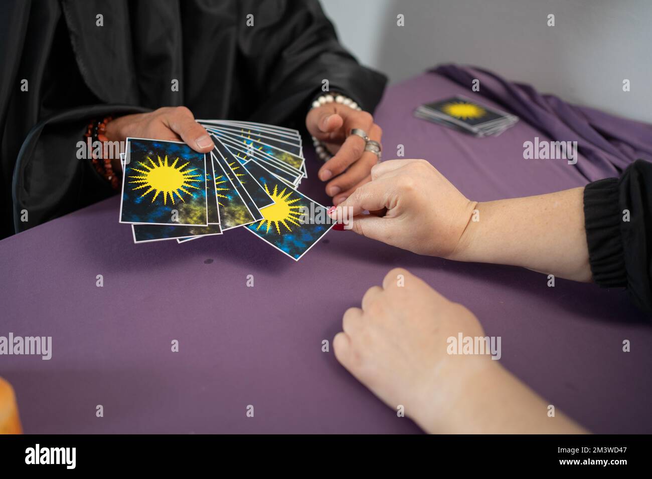 L'uomo sta leggendo le carte Tarocchi che trattano le carte per la donna in ufficio Foto Stock