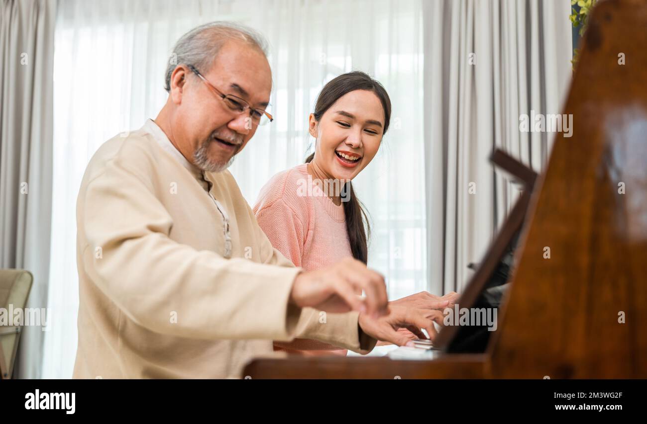 Giovane donna che insegna pianoforte per l'insegnamento di alto uomo Foto Stock
