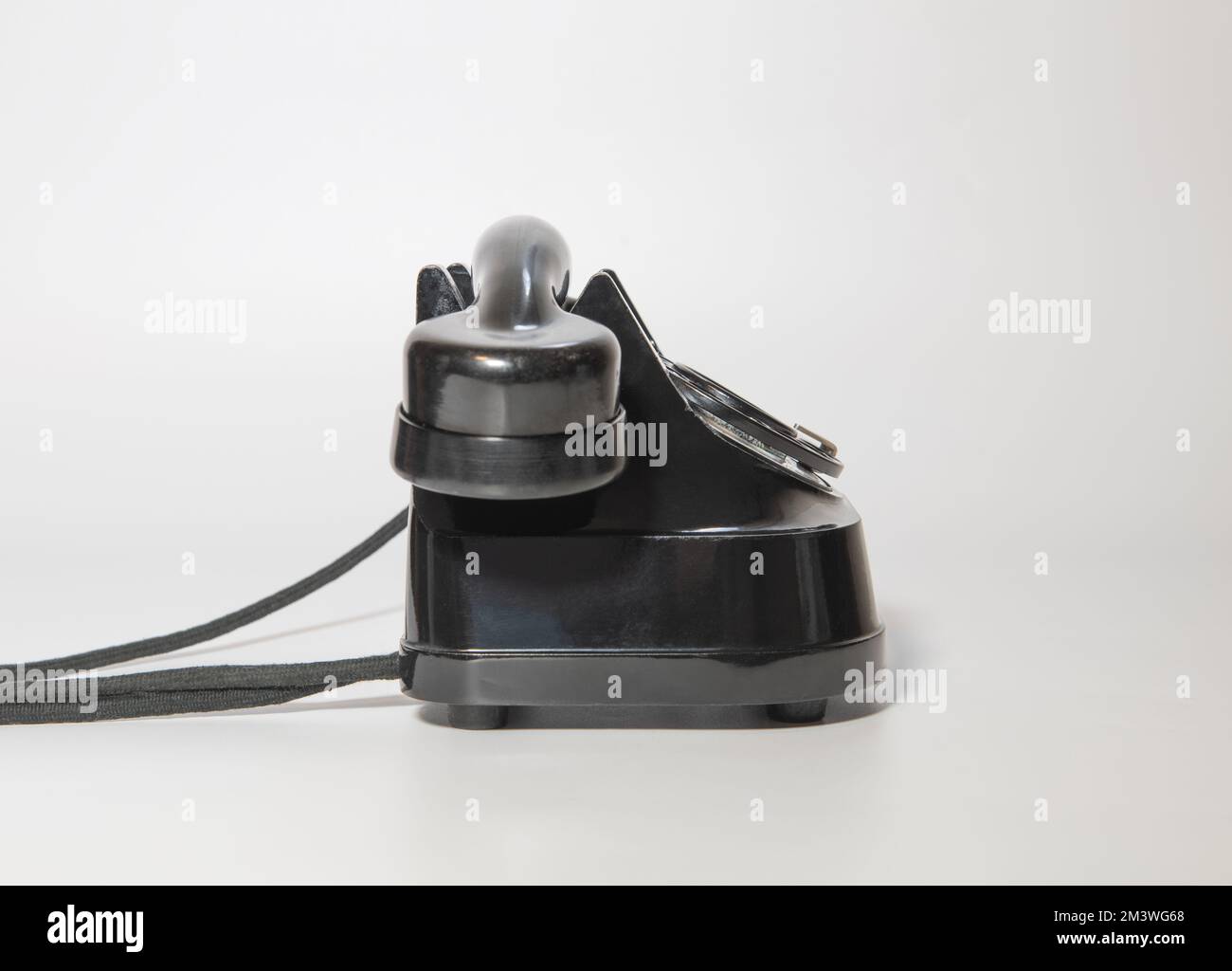 vecchio telefono nero rotante con tracce di tempo. vista lato sinistro. su sfondo bianco Foto Stock