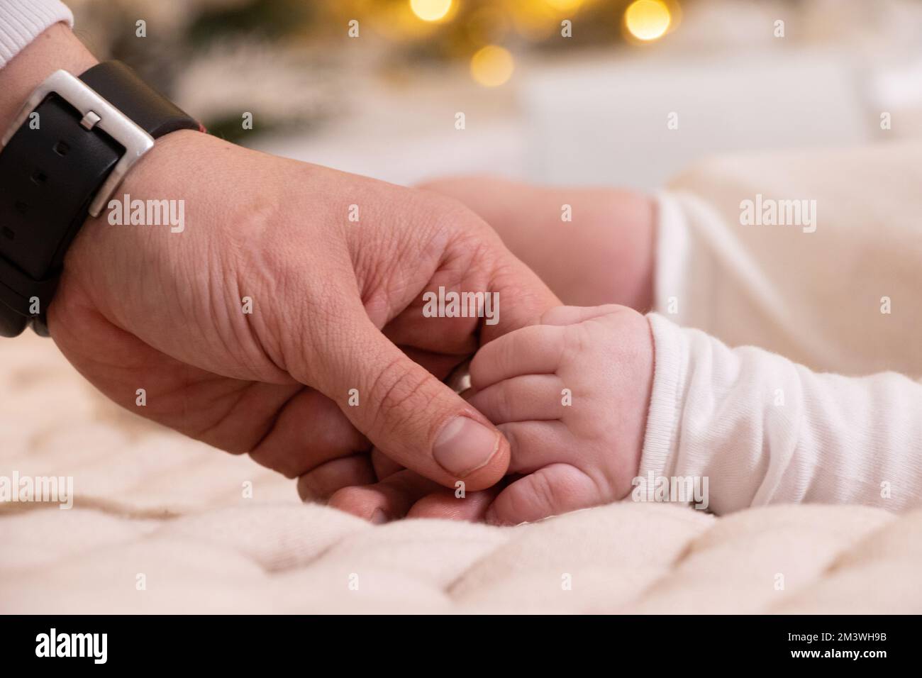 La mano del papà tiene la mano di un primo piano neonato, l'amore e la famiglia, la mano di un neonato, i bambini Foto Stock