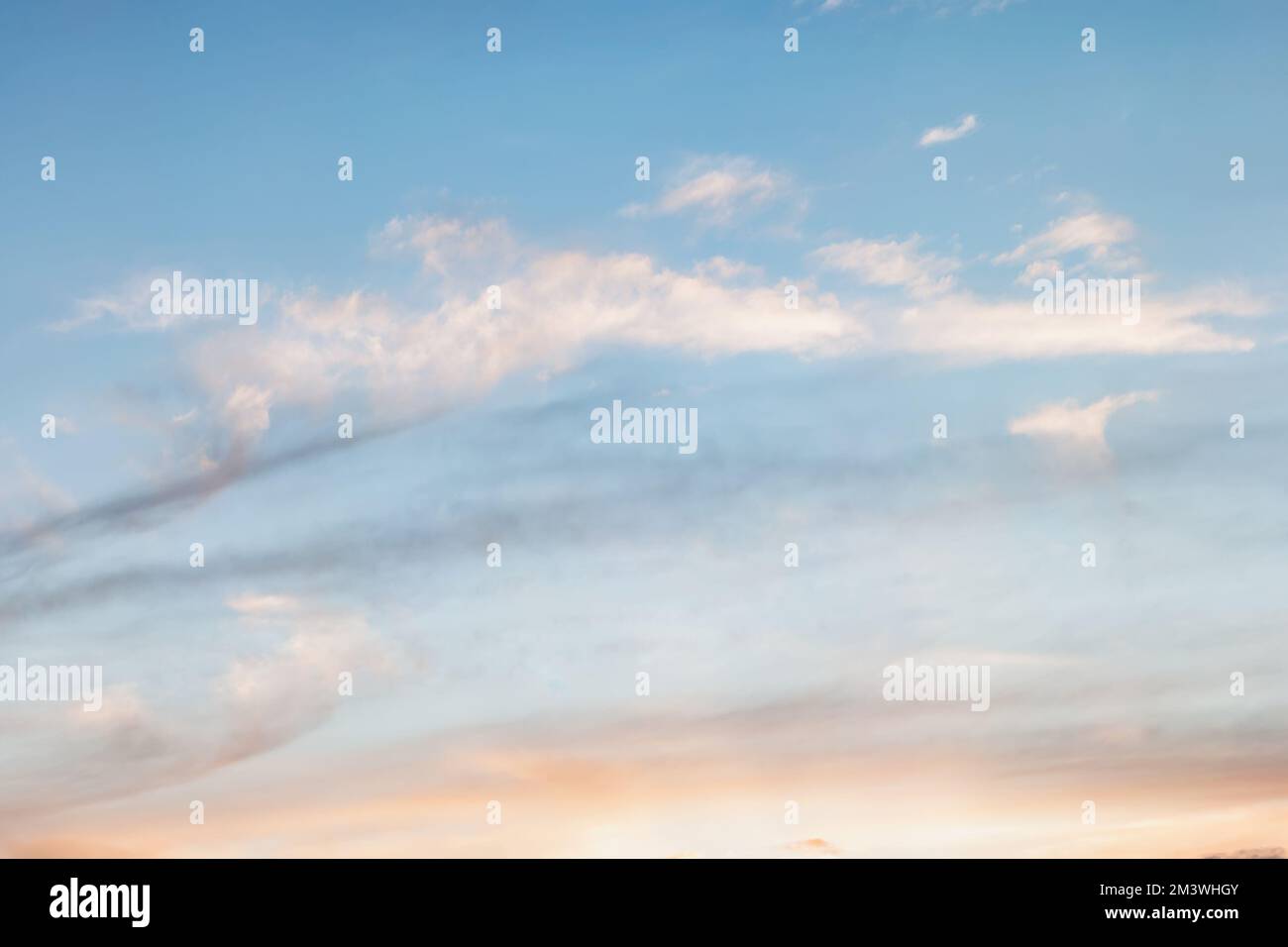 Sfondo del cielo serale, nuvole distese di luce al sole. Cielo con un gradiente di colore da caldo a freddo Foto Stock
