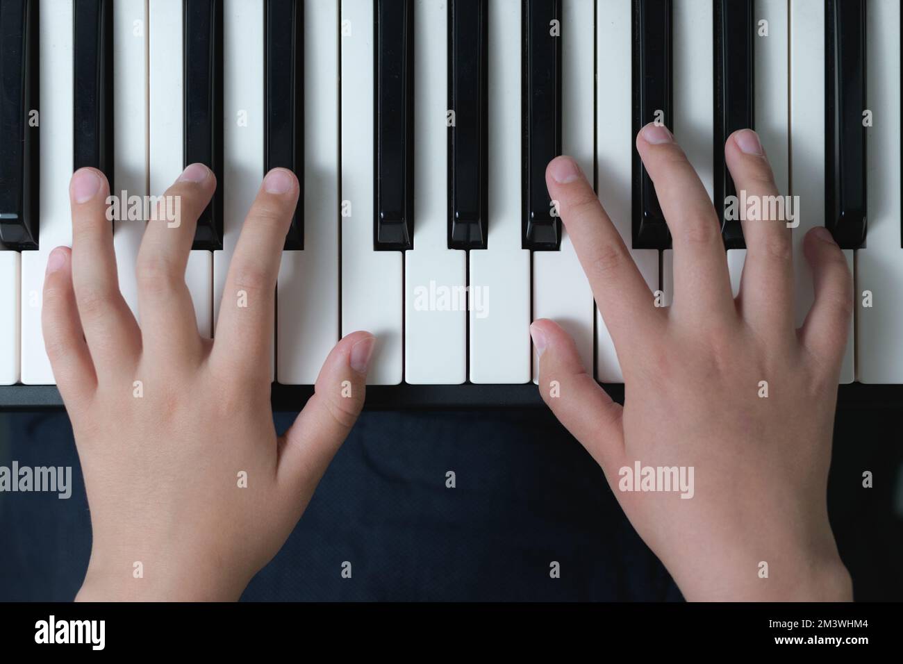 Le prime basi della musica. Dita di un bambino sulla tastiera del pianoforte. Primo piano Foto Stock