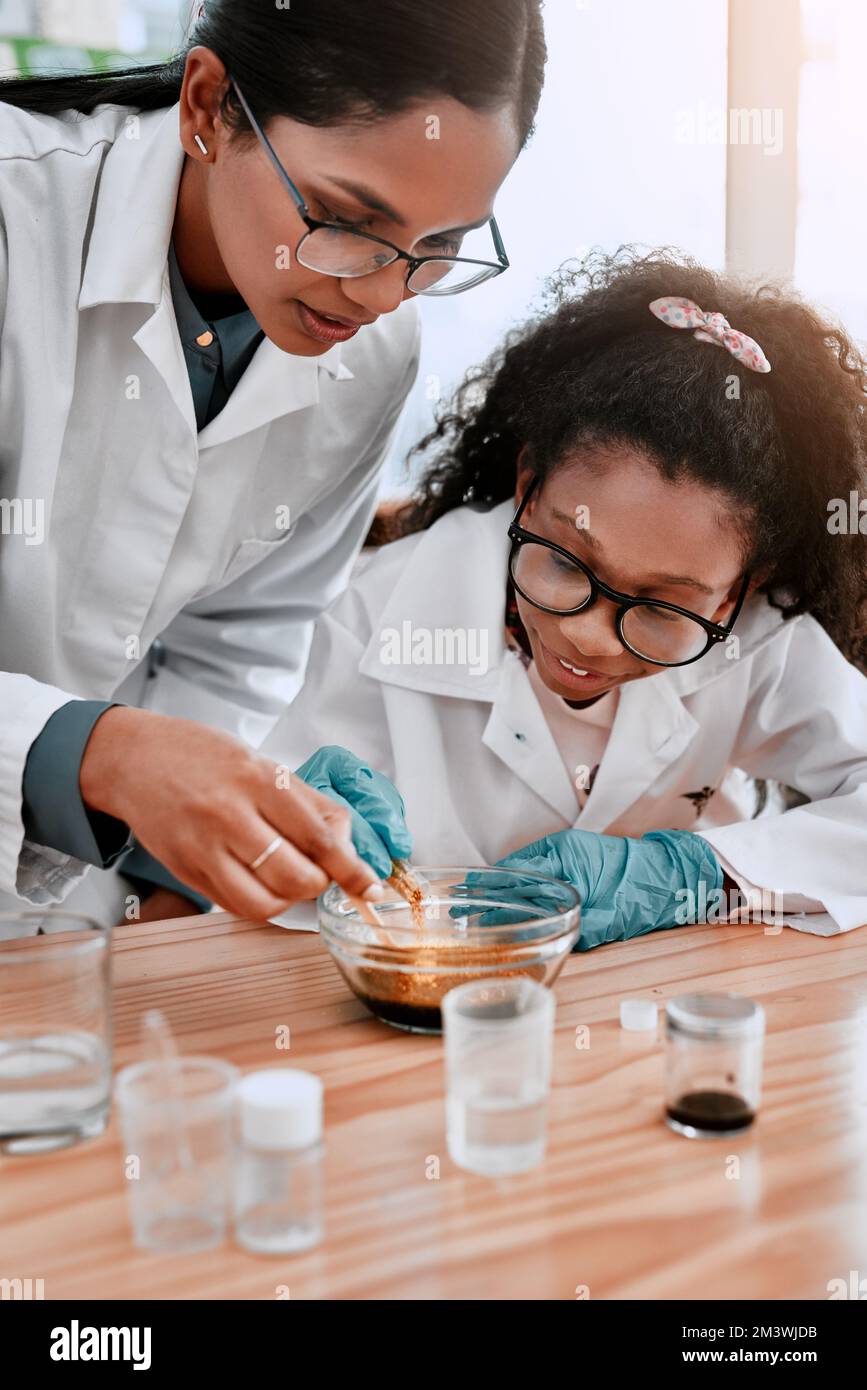 Lasciarli sperimentare fa parte dell'esperienza di apprendimento. una ragazza adorabile della scuola che fa un esperimento con la sua insegnante di scienza a scuola. Foto Stock