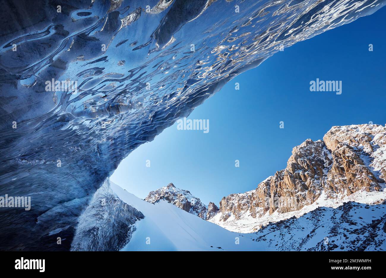 Bellissimo paesaggio di arco blu grotta di ghiaccio e montagne ricoperte di neve in Almaty, Kazakhstan Foto Stock
