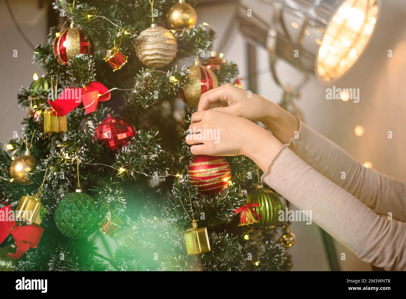 donna che tiene xmas ornamento primo piano. persona decorare l'albero di natale in una casa per la festa. auguri di stagione Foto Stock