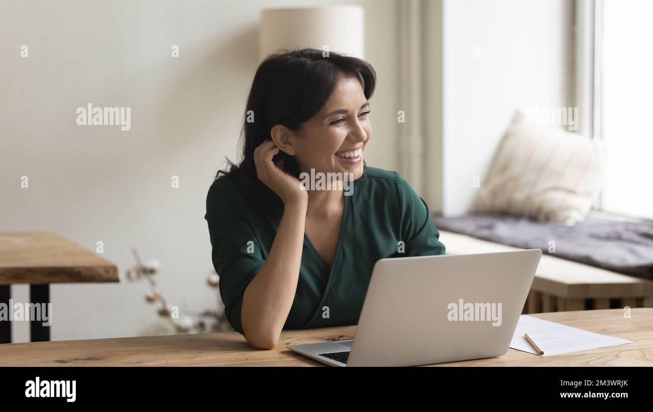 Donna di lavoro freelance felice che lavora al laptop nell'ufficio domestico Foto Stock