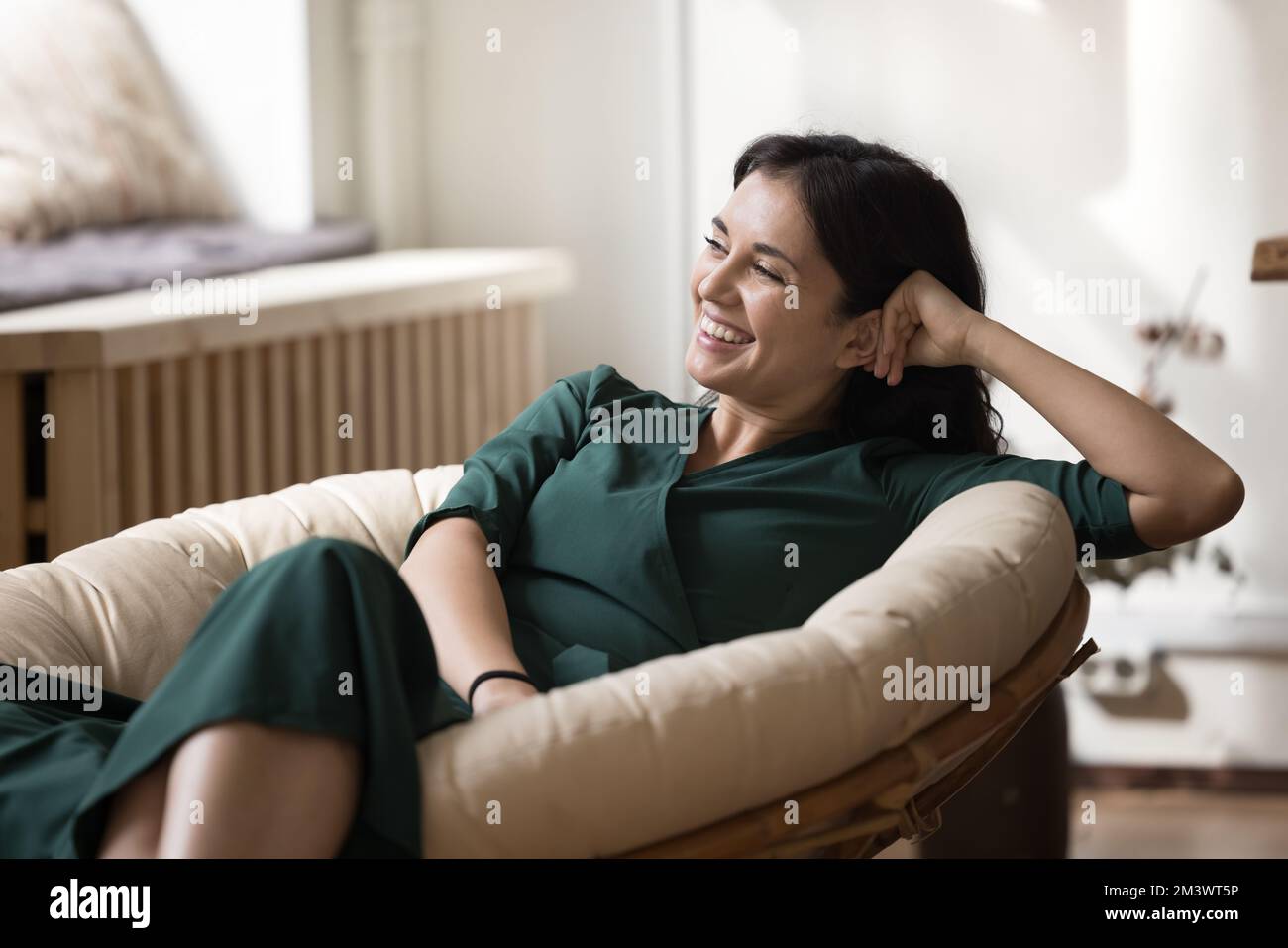 Allegro bella giovane donna proprietario di casa riposante in morbida poltrona elegante Foto Stock