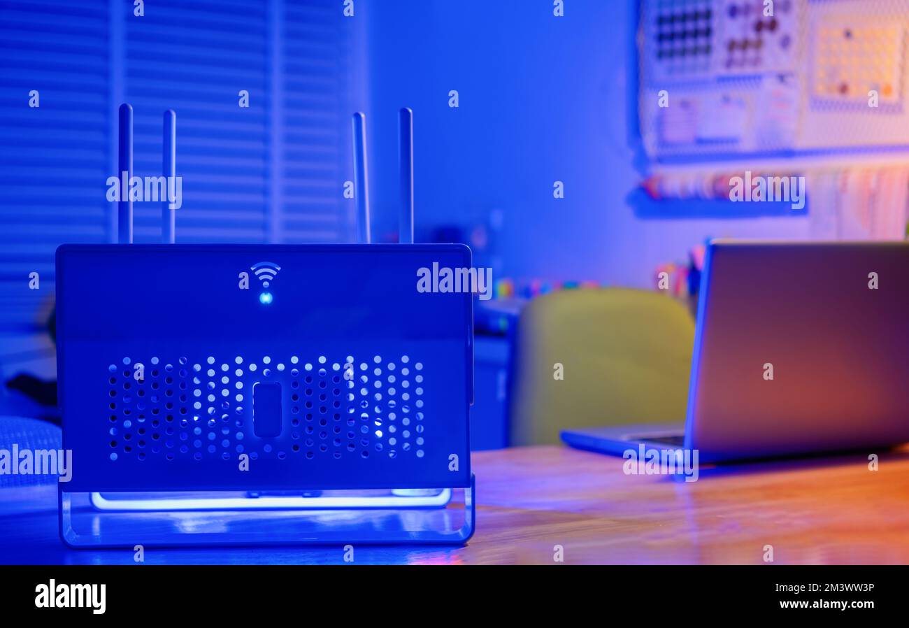 Primo piano di un router wireless e di computer portatili nel soggiorno di casa Foto Stock