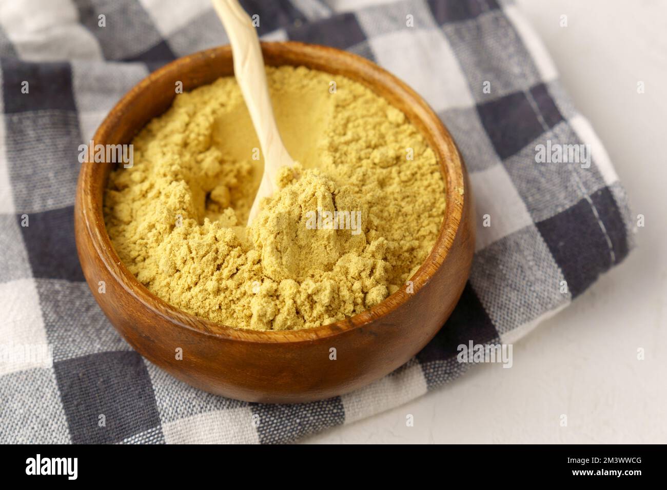 Polvere di senape in ciotola di legno. Le mostarde sono piante dei generi Brassica e Sinapis. Foto Stock