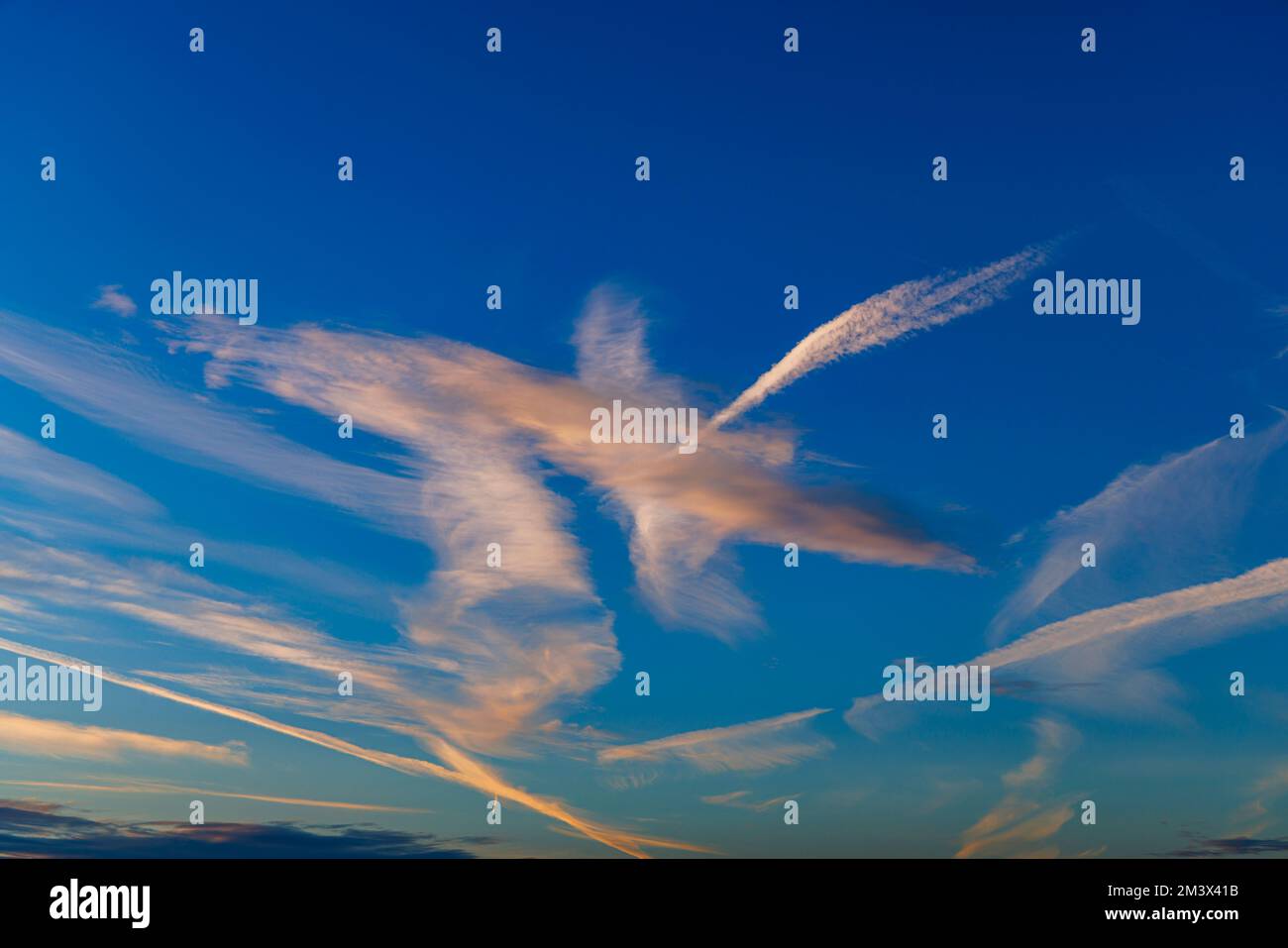 Contrails contro un cielo blu Foto Stock