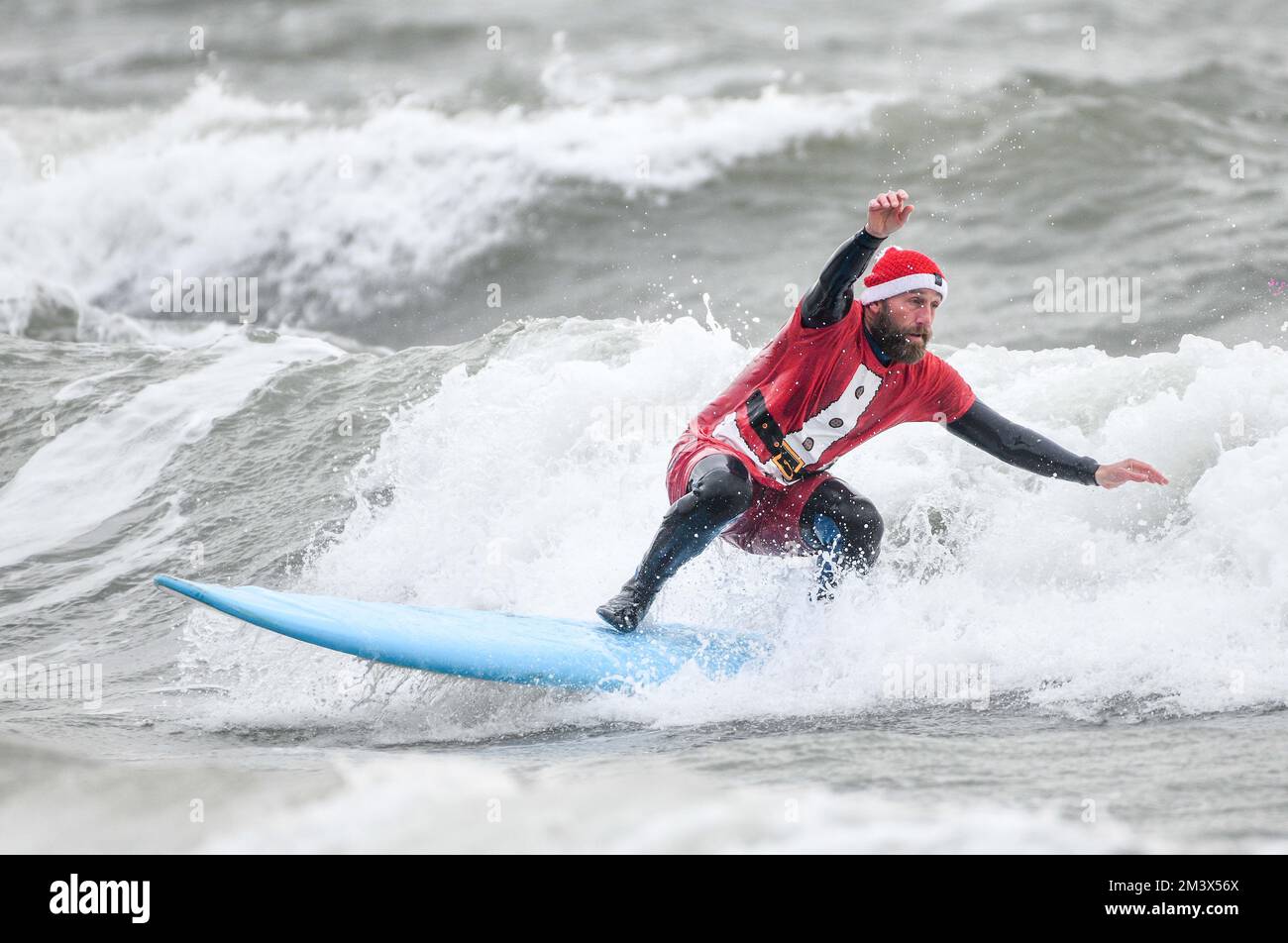 I raisers del fondo sfidano le acque ghiacciate a Langland Bay, Swansea durante l'evento annuale di Santa Surf che si svolge ogni anno presso la spiaggia di Gower per raccogliere soldi per i surfisti contro la rete fognaria e aiutare i surfisti locali a entrare nello spirito natalizio. Foto Stock