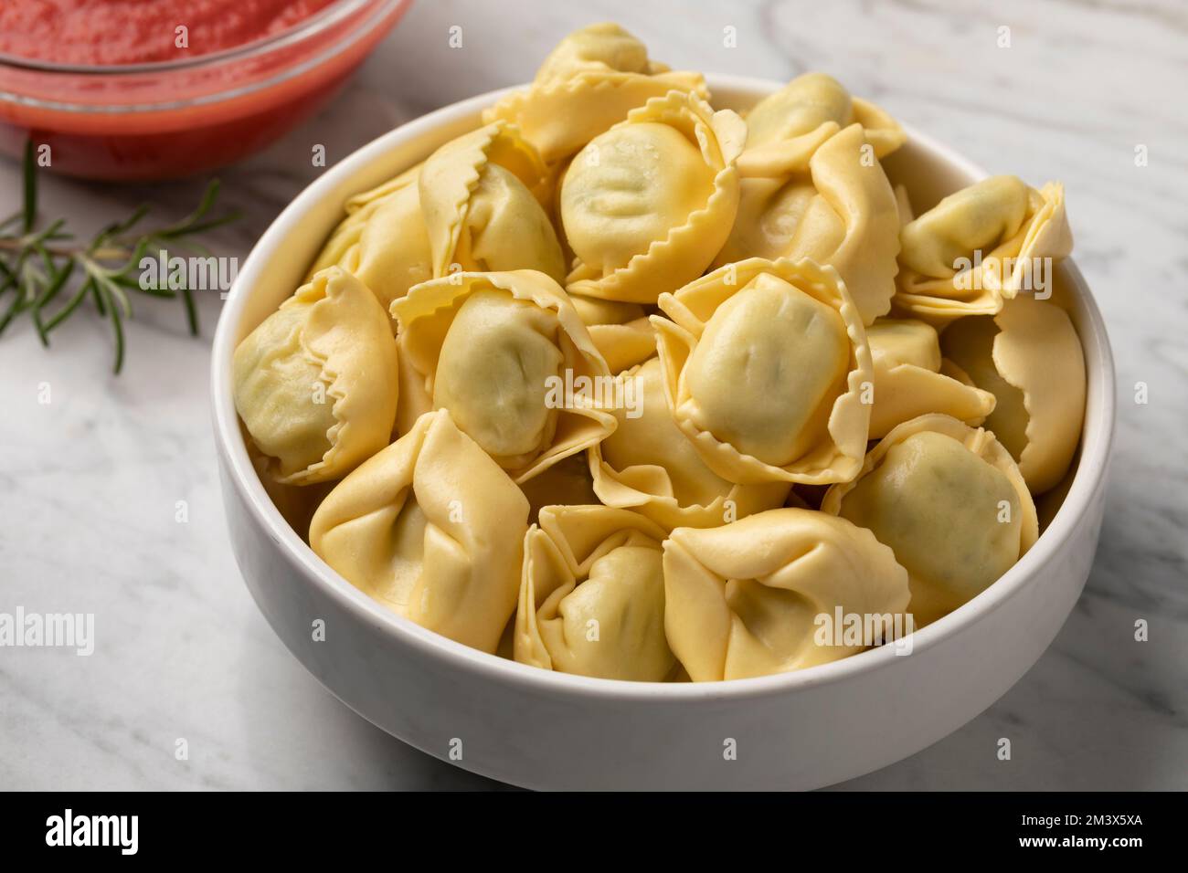 Ciotola con tortellini tradizionali italiani freschi ripieni di ricotta e spinaci da vicino Foto Stock