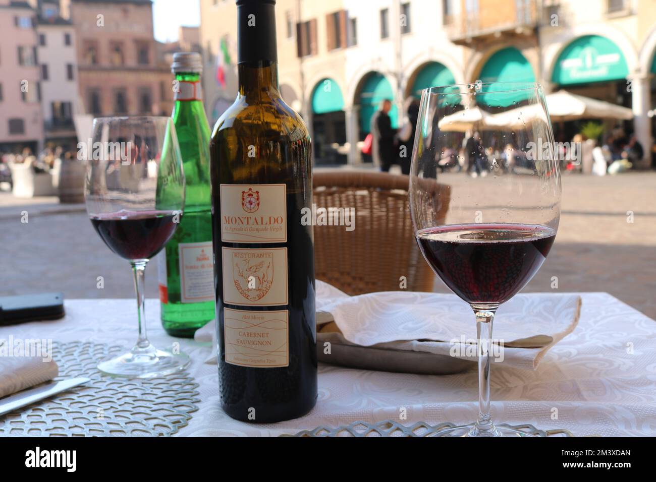 Cena all'aperto in una piazza vecchia, Piazza delle Erbe nel centro di Mantova, in Italia, guardando gli archi di negozi antichi Foto Stock