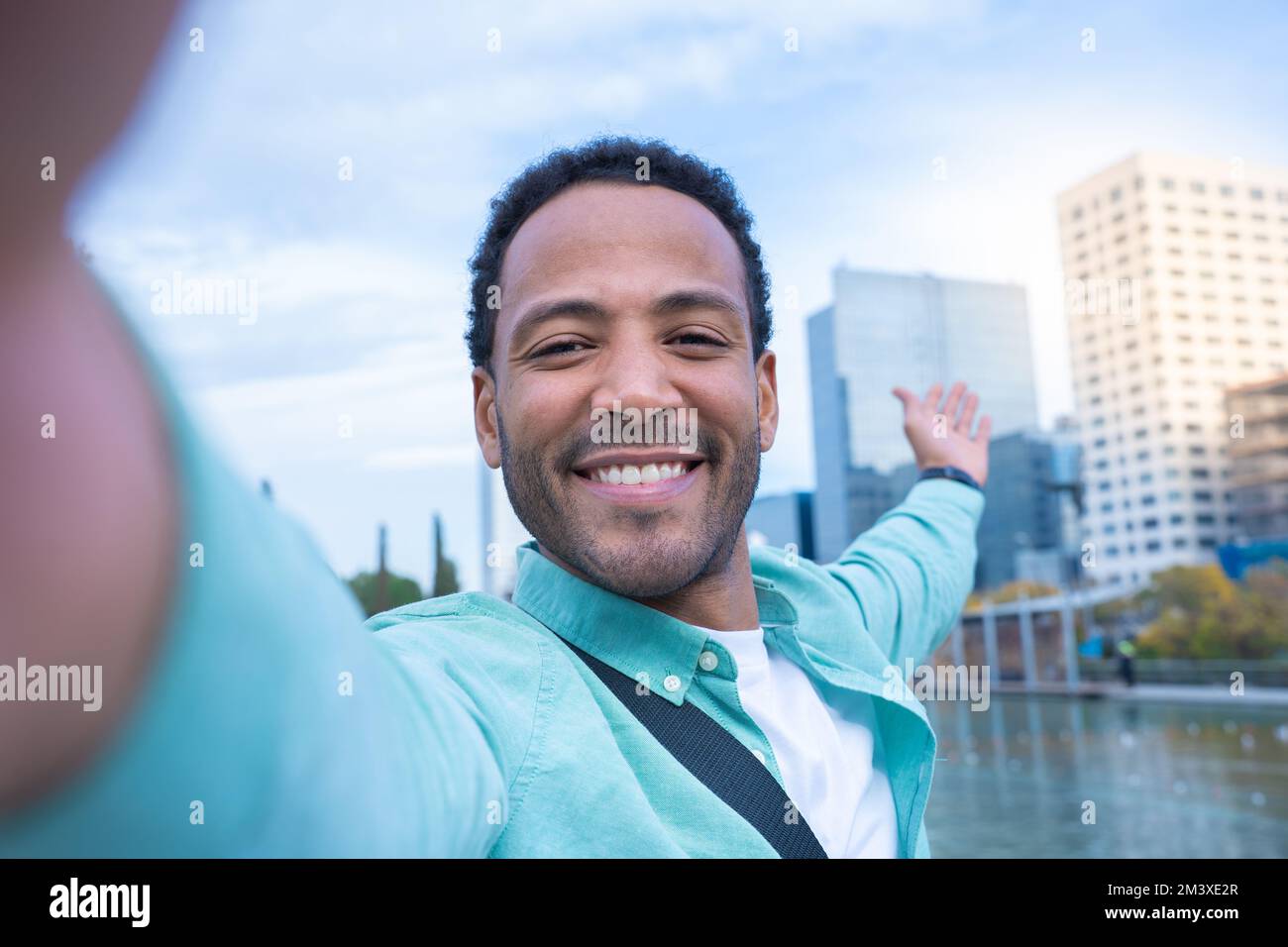 Giovane afro-americano che prende un selfie sorridendo felice mostrando la nuova città in cui vive. Foto Stock
