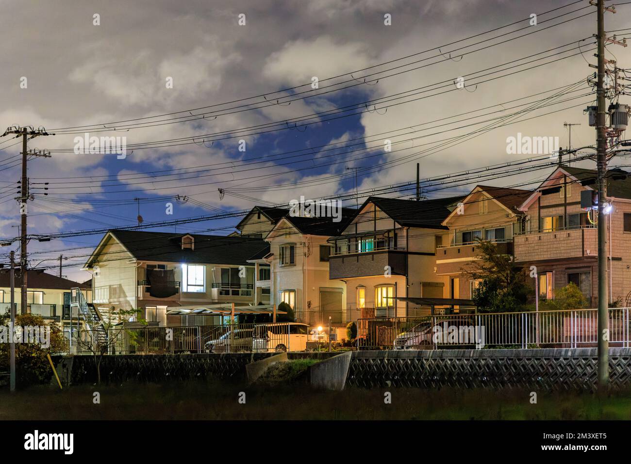 Case suburbane a due piani su una strada tranquilla sotto le nuvole di notte Foto Stock