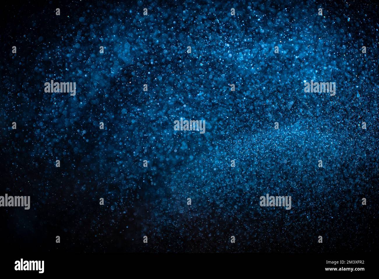 Particelle di polvere blu su sfondo nero. Scintillante overlay bokeh con spazio per le copie. Foto Stock