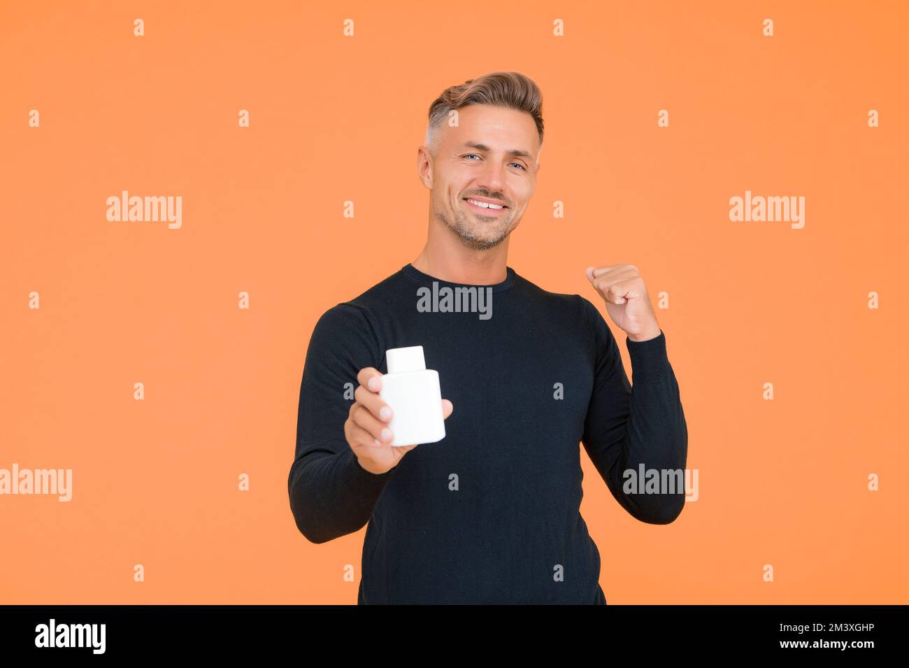 Colonia, che vi farà crescere la vostra fiducia. Uomo felice presente deodorante gesturing con sicurezza. Negozio di profumi. Cura del corpo da uomo. Balsamo post-rasatura. Dopo Foto Stock