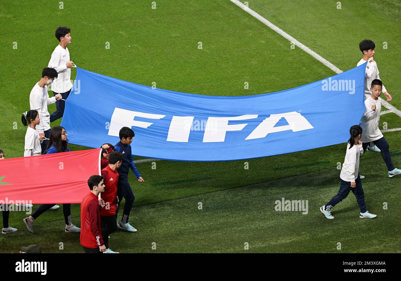 Doha, Qatar. 17th Dec, 2022. I giovani portacolori della bandiera cinese detengono la bandiera FIFA durante la cerimonia di pre-partita del terzo incontro di play-off tra Croazia e Marocco della Coppa del mondo FIFA 2022 allo Stadio Internazionale Khalifa di Doha, Qatar, il 17 dicembre 2022. Credit: Xia Yifang/Xinhua/Alamy Live News Foto Stock