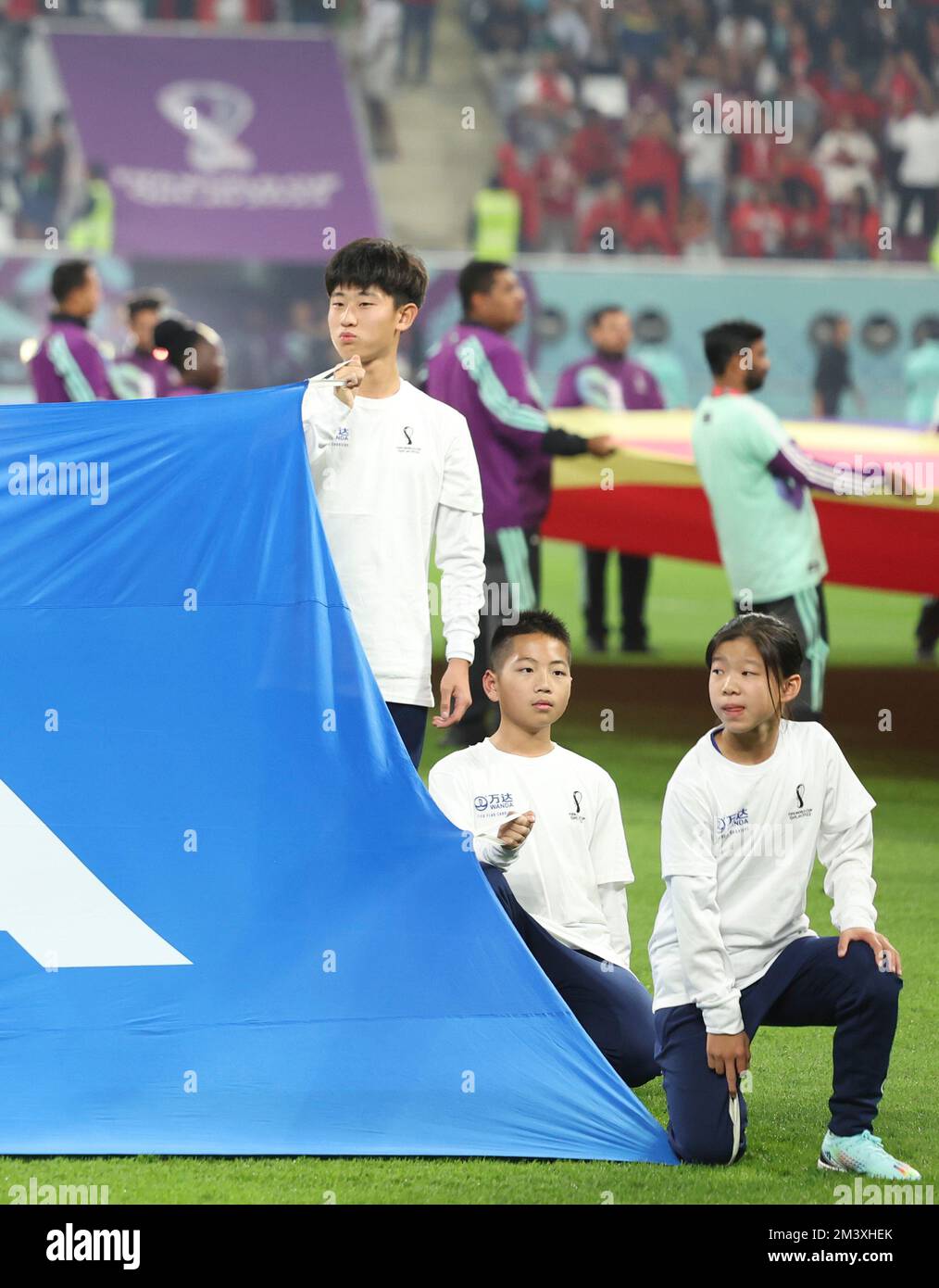 Doha, Qatar. 17th Dec, 2022. I giovani portacolori della bandiera cinese detengono la bandiera FIFA durante la cerimonia di pre-partita del terzo incontro di play-off tra Croazia e Marocco della Coppa del mondo FIFA 2022 allo Stadio Internazionale Khalifa di Doha, Qatar, il 17 dicembre 2022. Credit: Jia Haocheng/Xinhua/Alamy Live News Foto Stock