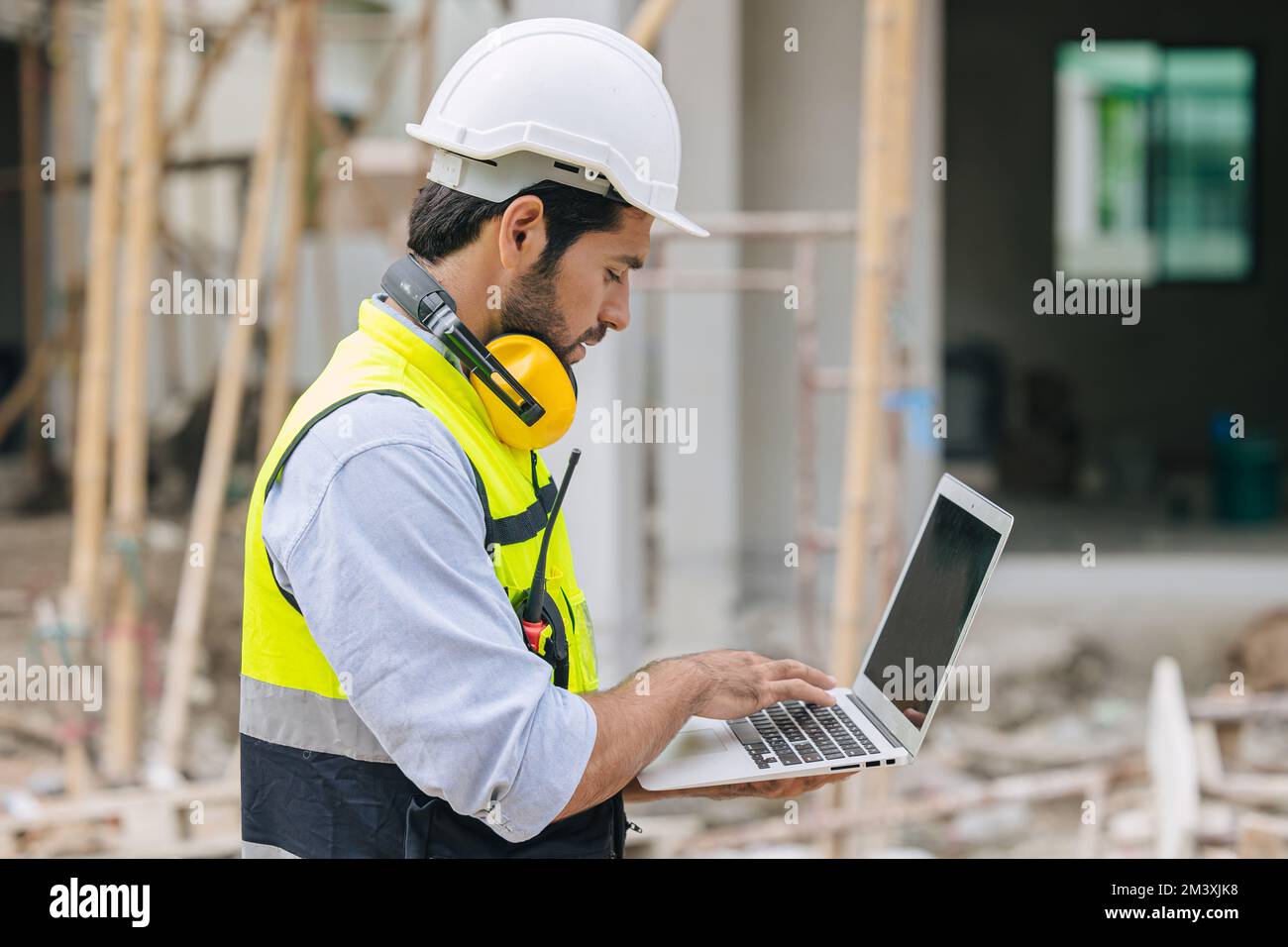 capocantiere di un ingegnere edile che lavora in contatto con il computer portatile in cantiere Foto Stock