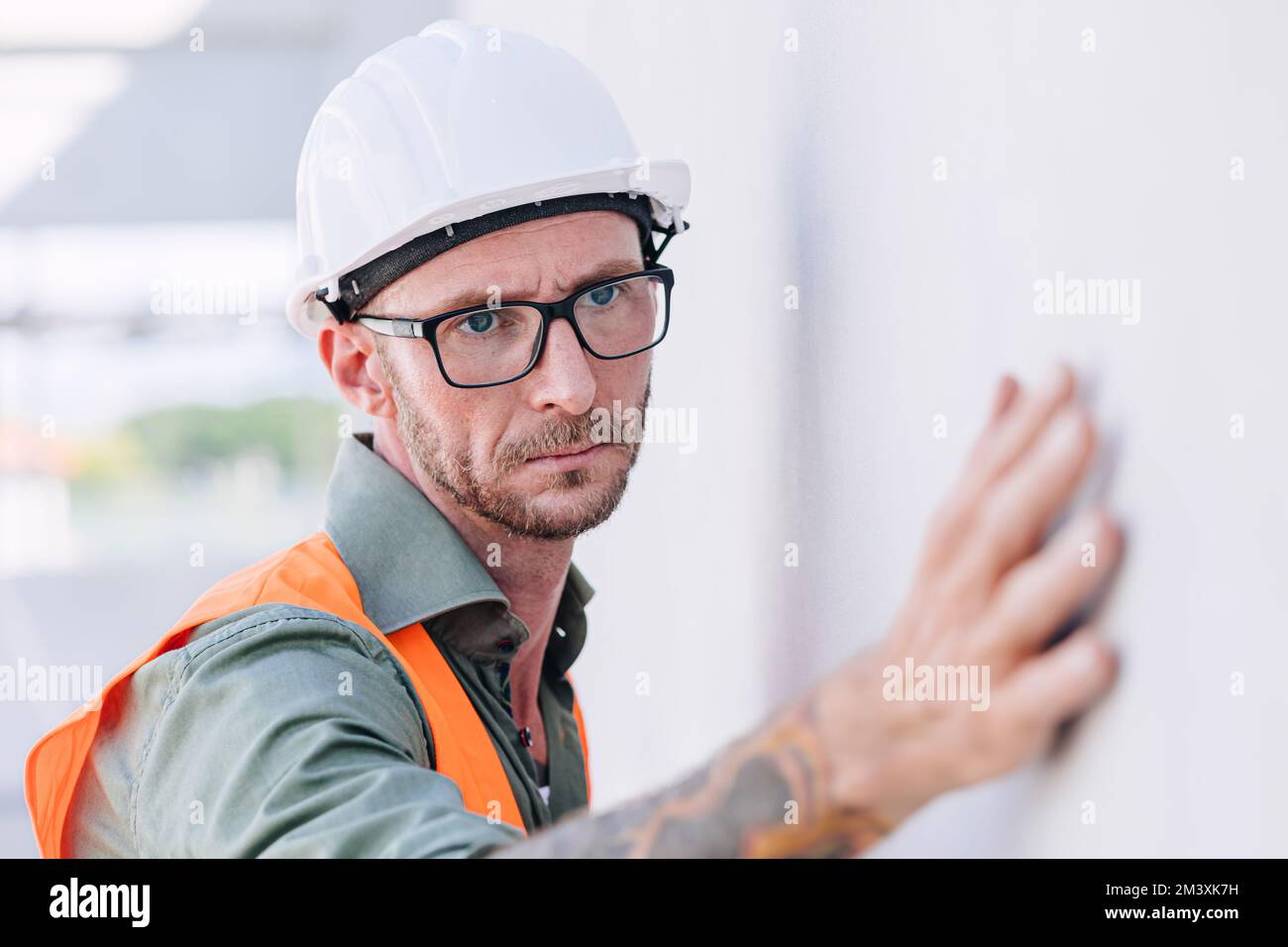 costruttore lavoratore guardare a costruzione intonacando muro per dettagli di alta precisione e qualità per una buona costruzione a casa Foto Stock