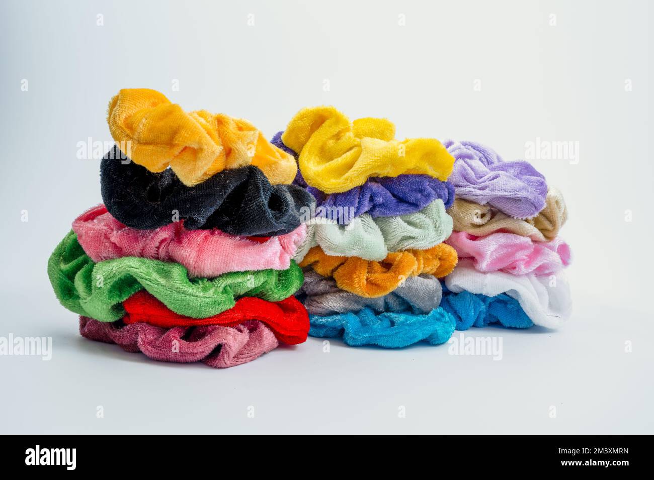 tre mucchi lavati di crunchietti elasticizzati in velluto isolati su fondo bianco Foto Stock