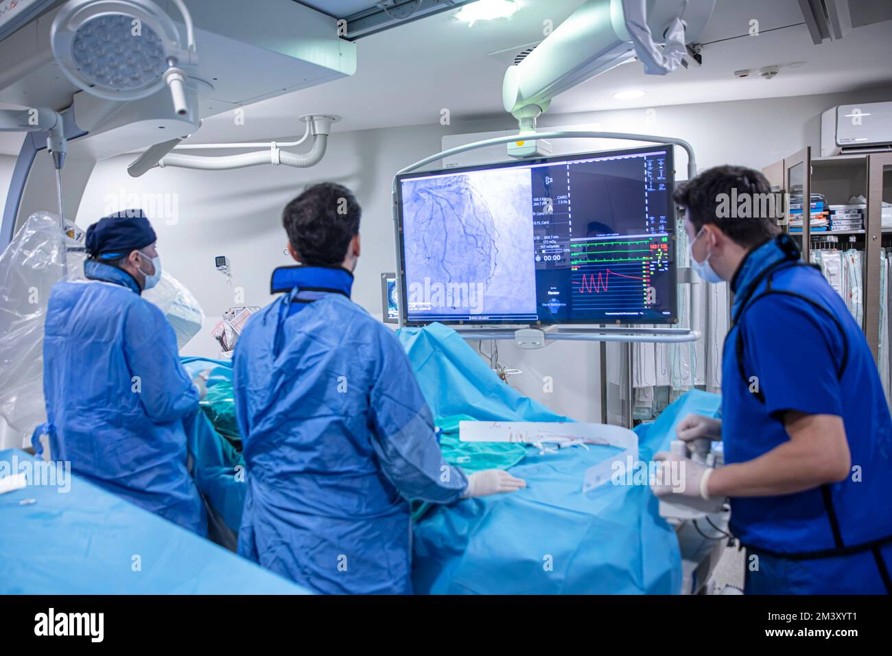 Istanbul, Turchia - 20 settembre 2022; sala operatoria del cuore. Cardiofrequenzimetro con linee di battito cardiaco multicolore contro il gruppo di chirurghi che lavorano i Foto Stock