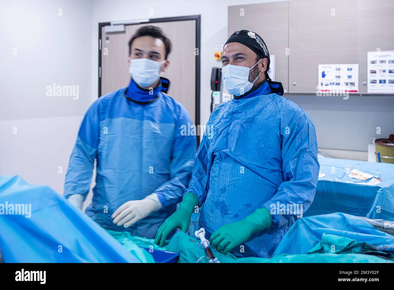 Istanbul, Turchia - 20 settembre 2022; sala operatoria del cuore. Cardiofrequenzimetro con linee di battito cardiaco multicolore contro il gruppo di chirurghi che lavorano i Foto Stock