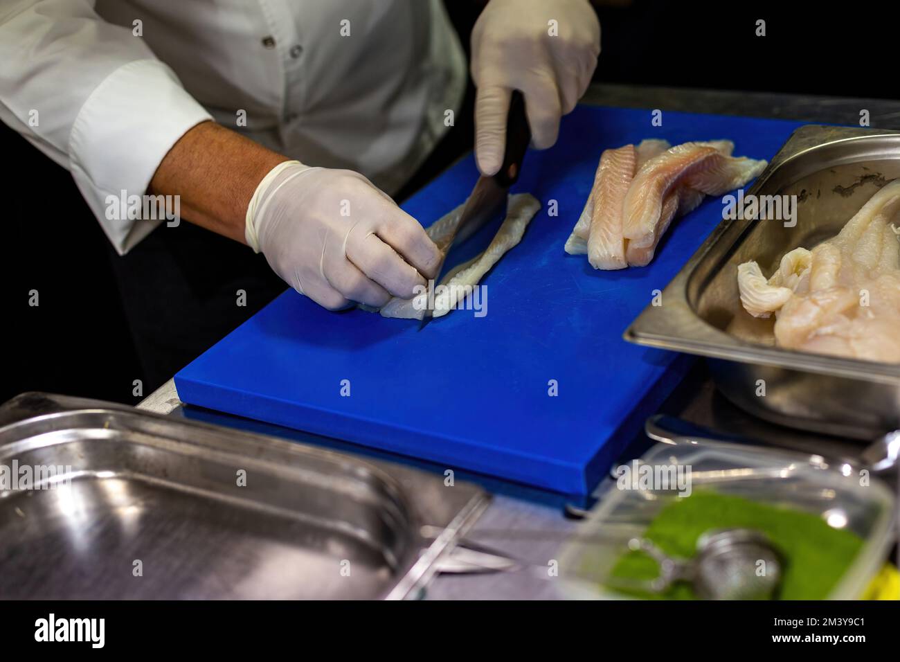 Il cuoco trita la suola. Tagliare il pesce con un coltello. Foto Stock