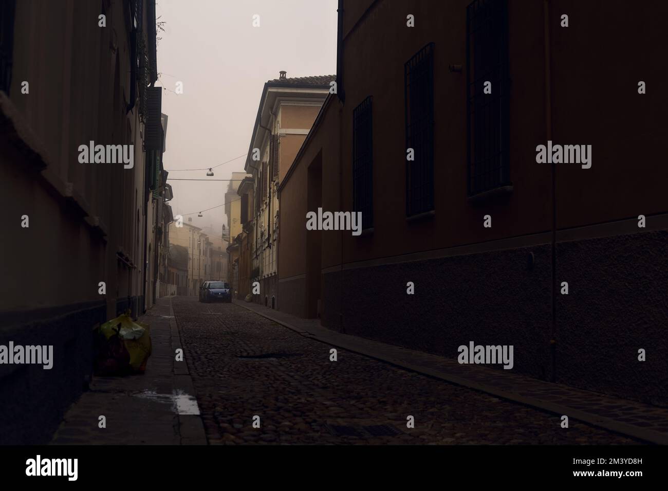 Strada acciottolata stretta in una giornata di nebbia Foto Stock