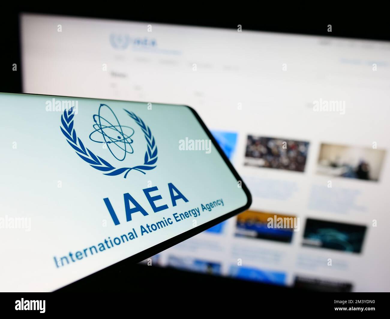 Smartphone con logo dell'Agenzia internazionale dell'energia atomica (AIEA) sullo schermo davanti al sito Web. Messa a fuoco al centro a destra del display del telefono. Foto Stock