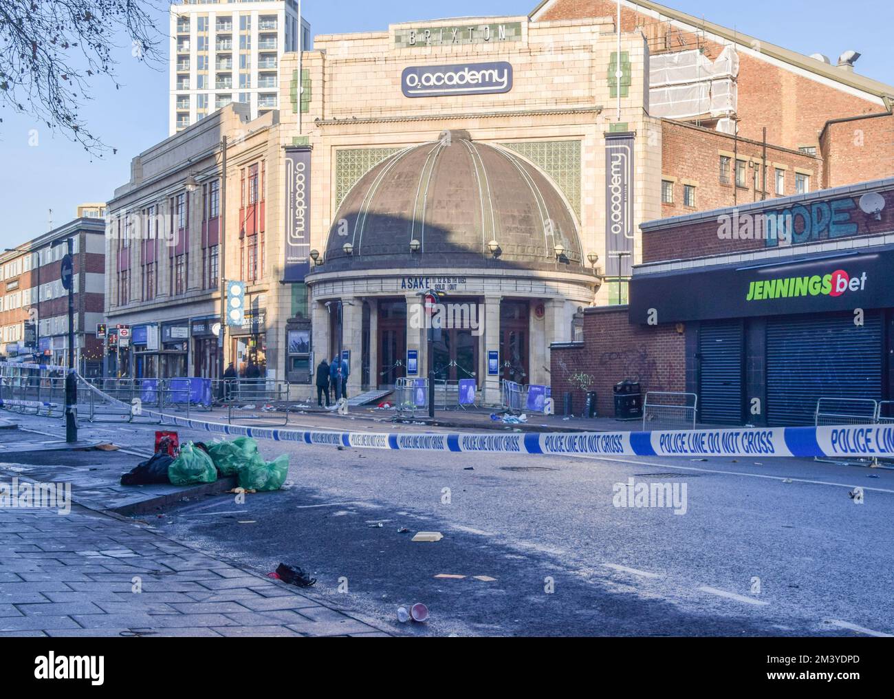 Un cordone di polizia visto al di fuori della O2 Academy Brixton la mattina dopo lo spettacolo. Una donna è morta e altre due persone sono in ospedale in condizioni critiche dopo essere state schiacciate durante un concerto dal cantante Asake nel famoso locale di musica dal vivo nel sud di Londra. Foto Stock