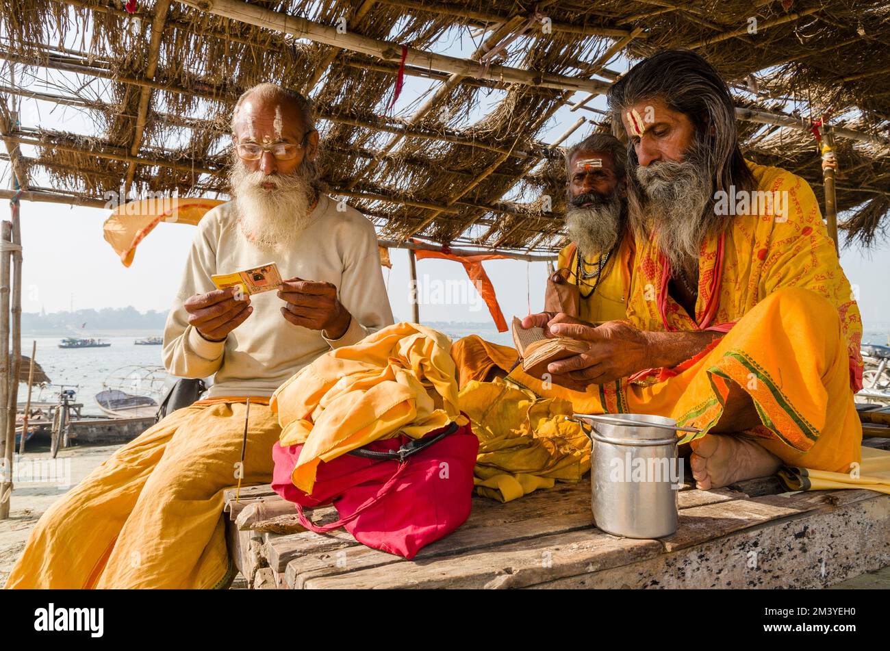 Sadhus recita dai libri sacri la mattina a Sangam, la confluenza dei fiumi santi Ganges, Yamuna e Saraswati Foto Stock