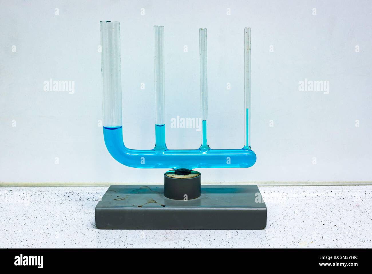 Apparecchiature in vetro in cui diversi tubi collegati sono riempiti con un liquido blu, a dimostrazione dell'azione capillare. Utilizzato nella classe fisica. Foto Stock