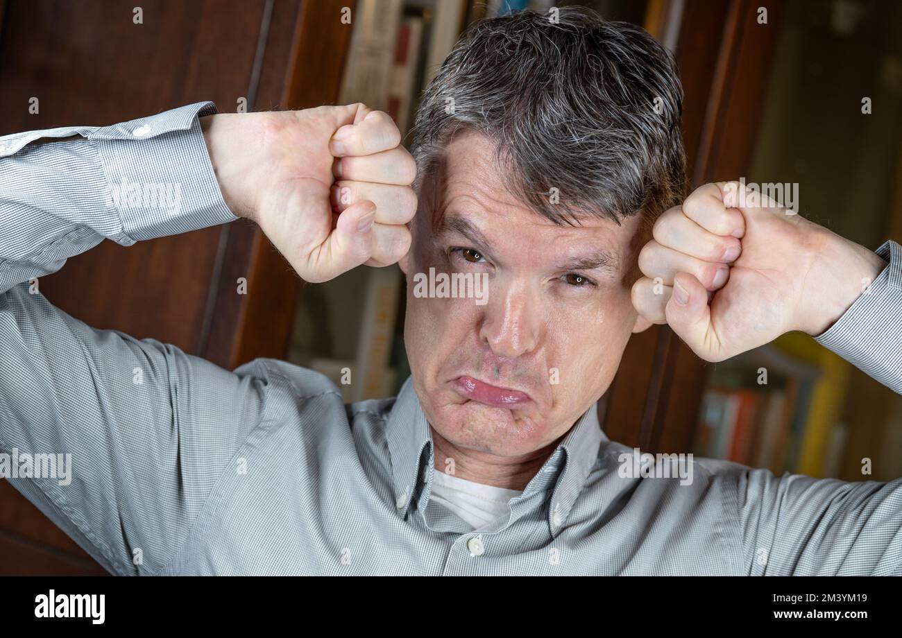 Arrabbiato e stressato, uomo di mezza età con pugni clenched. Foto Stock