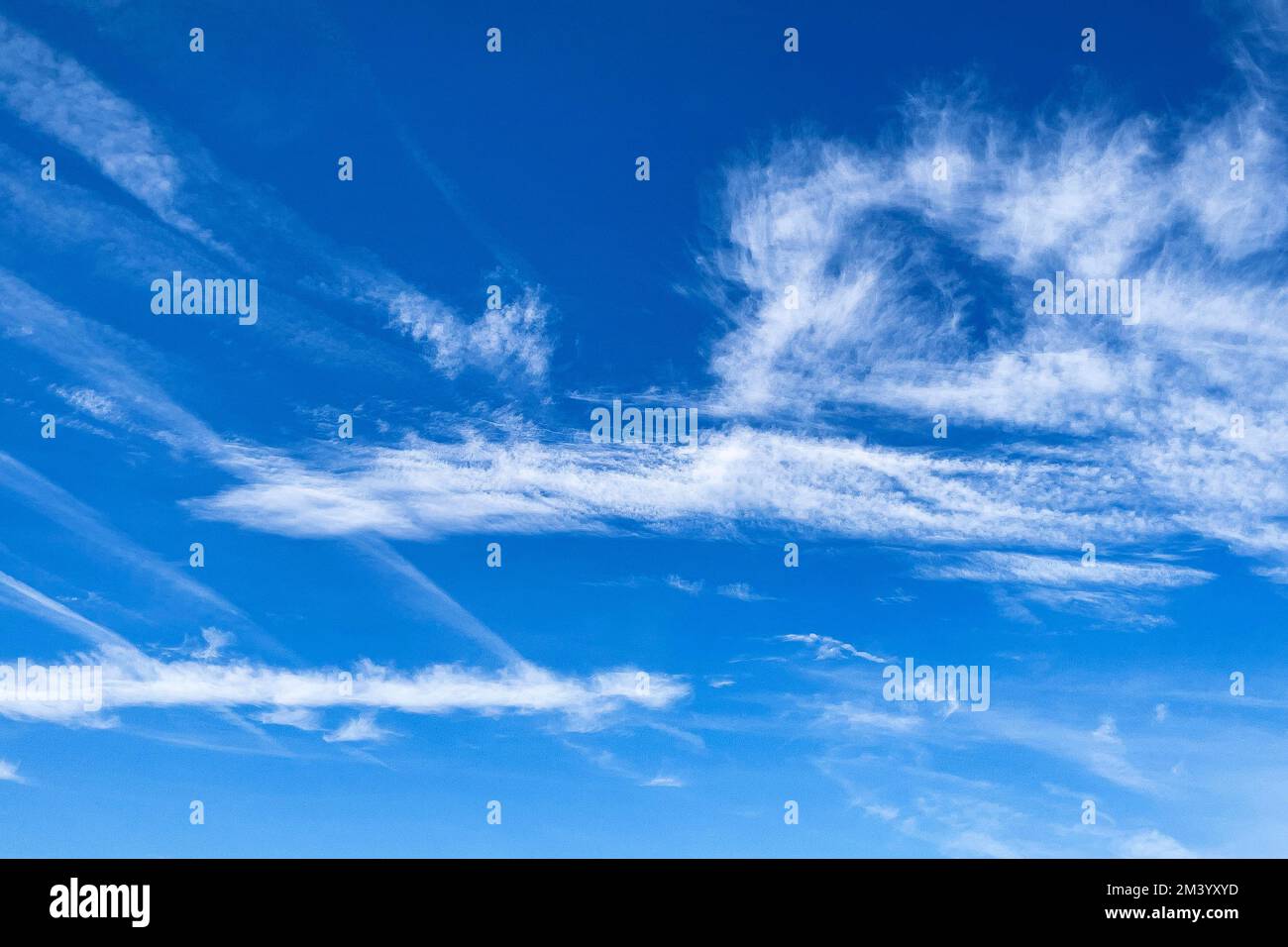 Cielo blu con le nuvole di piuma di Cirrus a sinistra le nuvole di cluster di Cirrocumulus a destra, piccole nuvole di strato medio-alto Altostratus al centro Foto Stock