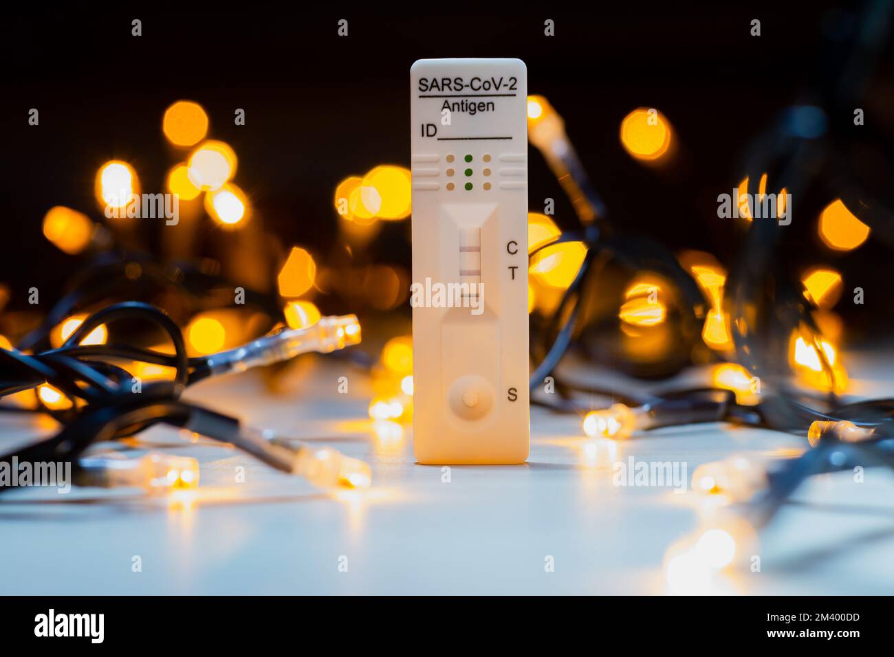 Test corona positivo con luci natalizie sullo sfondo Foto Stock