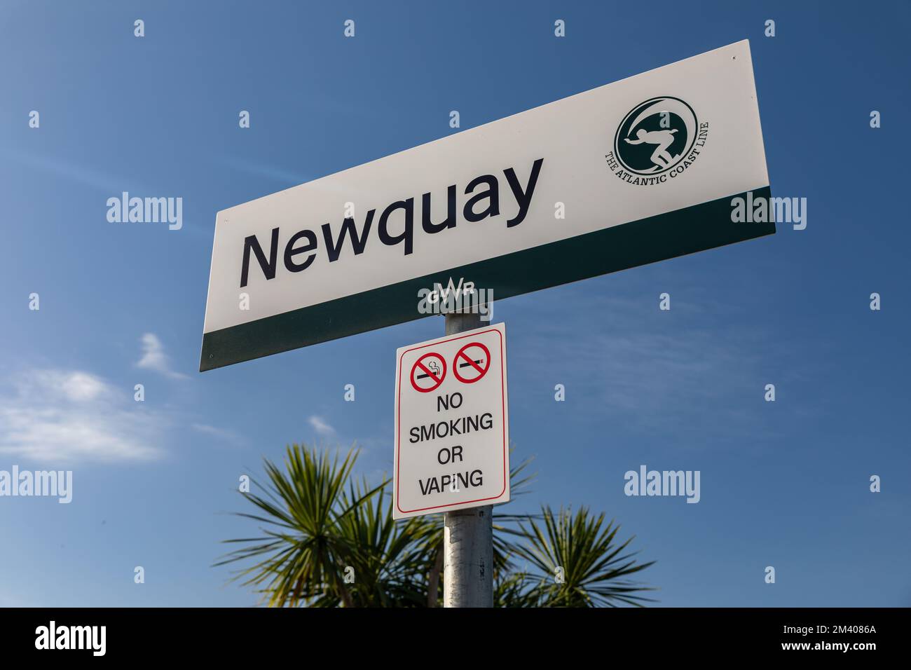 Cartellone della stazione ferroviaria di Newquay con la scritta GWR sotto un cielo azzurro, che mostra la banchina e i dettagli della stazione in Cornovaglia, Regno Unito Foto Stock