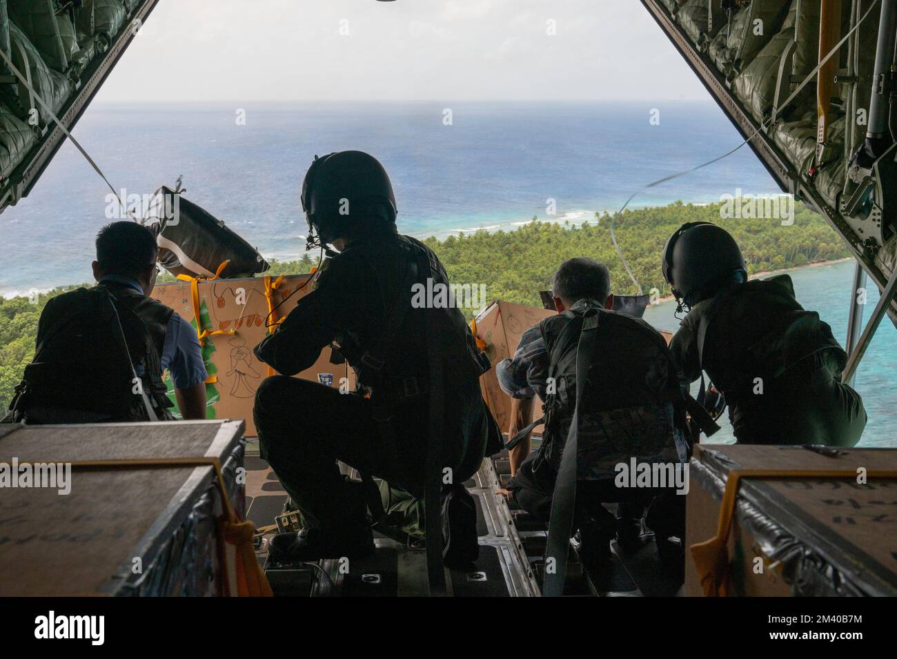 Isola RUO, Stati Federati di Micronesia. 06 dicembre 2022. L'Airman dell'aeronautica statunitense e giapponese lascia un fascio dalla rampa di un aeromobile JASDF C-130H Hercules durante l'operazione Christmas Drop 2022, 6 dicembre 2022 a RUO Island, FSM. Operazione Christmas Drop è la più antica missione umanitaria e di soccorso in caso di disastri che offre 71.000 chili di cibo, regali e forniture per assistere le comunità remote dell'isola nel Pacifico meridionale. Credit: A1c Allison Martin/US Airforce Photo/Alamy Live News Foto Stock