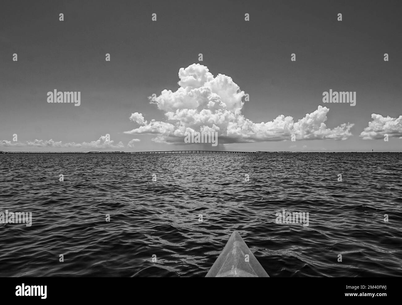 Kayak verso una tempesta di pioggia in lontananza su un ponte a Tampa Bay, Florida, USA in bianco e nero Foto Stock