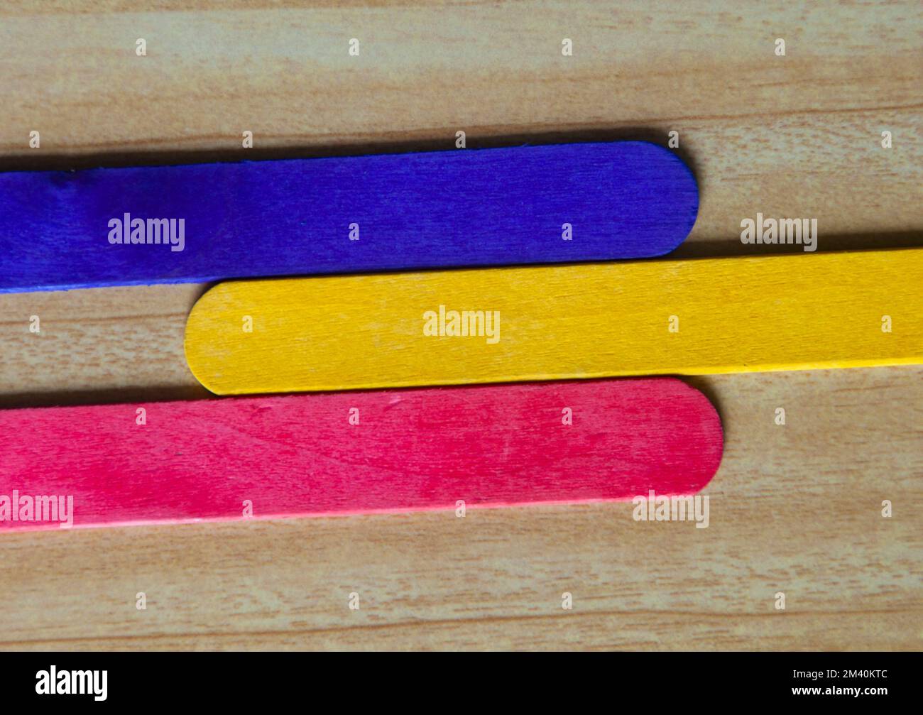 Vista dall'alto di bastoni di legno colorati con spazio personalizzabile per il testo. Concetto di spazio di copia e sfondo a colori. Foto Stock