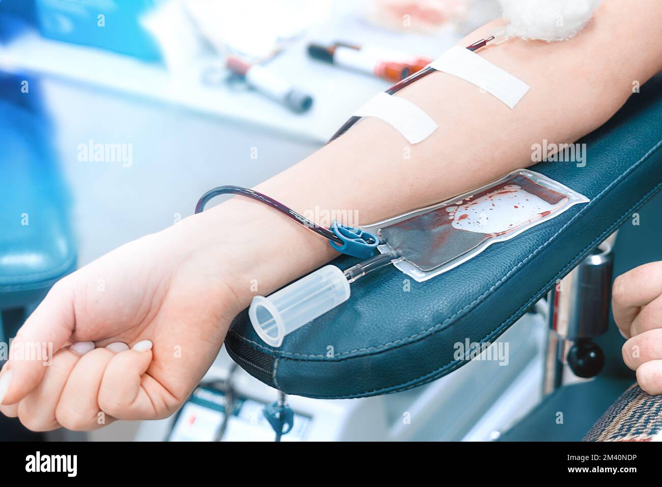 Il donatore dona il sangue alla stazione di trasfusione del sangue. Mano di donna con sacco per la donazione di sangue da vicino. Il volontariato salva vite umane. Tema della donazione. Sfondo.. Foto Stock