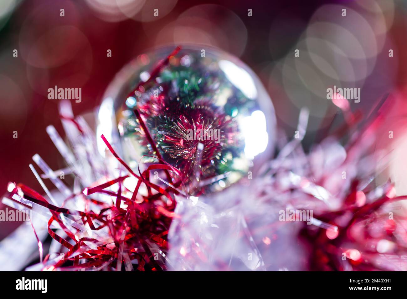 Decorazioni di Natale su un albero attraverso la sfera di obiettivo, macro sparato primo piano Foto Stock